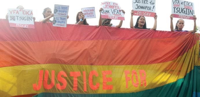 File photo shows protesters hanging a rainbow banner from the footbridge near the US embassy in Manila durling a protest over the killing of Jennifer 