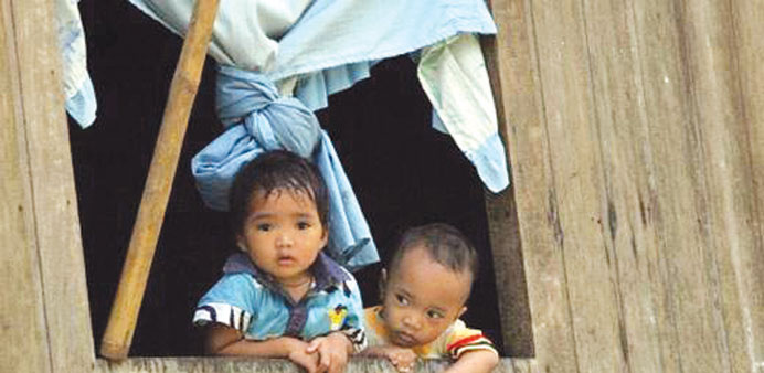 Children look out from a house at a sprawling MILF camp in the southern Philippines.