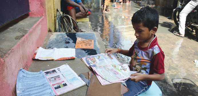  A boy puts his school books out to dry as floodwaters recede in Chennai.
