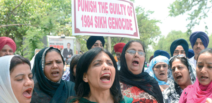 Sikh protesters hold placards as they shout anti-government slogans in front of Congress chief Sonia Gandhiu2019s residence in New Delhi yesterday.