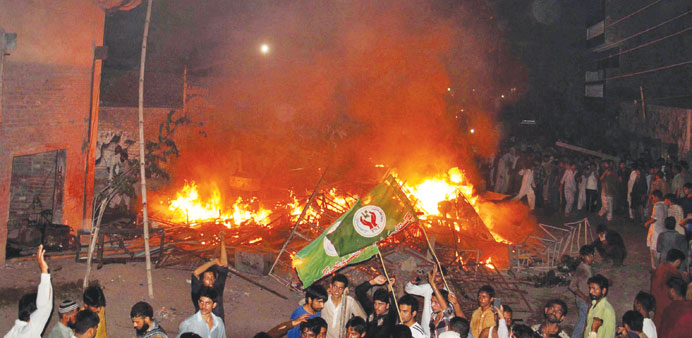 This photograph taken on July 27 shows an angry mob after it set fire to household items belonging to a resident in the low-income Arafat Colony of th