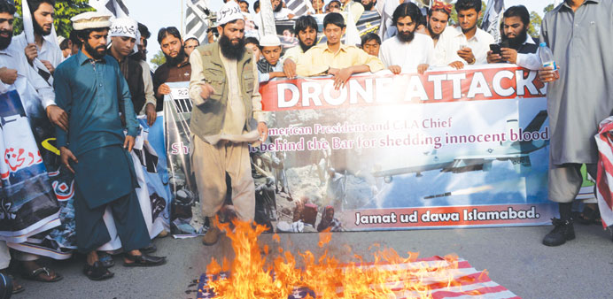 Activists of the banned Pakistanu2019s charity organisation Jamaat-ud-Dawa (JuD) torching a US flag during a protest against US drone attacks in Pakistani