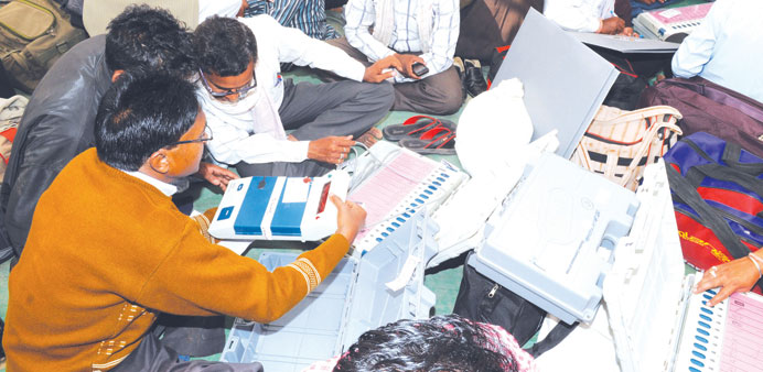 Polling officials check Electronic Voting Machines (EVMs) at a distribution centre in Rajnand Gaon district Chhattisgarh ahead of assembly elections.