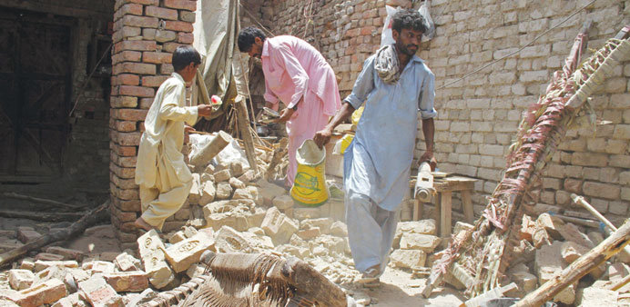 People affected by the earthquake searching through the rubble of their destroyed homes, in Nawabshah district of Sindh province yesterday.