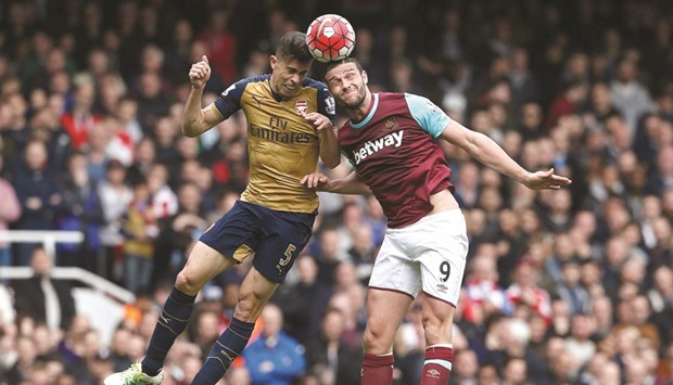Arsenalu2019s Brazilian defender  Gabriel (L) vies for the ball with West Ham Unitedu2019s English striker Andy Carroll during their English Premier League match at The Boleyn Ground in Upton Park, east London, yesterday.