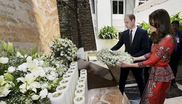 Prince William and his wife Catherine, Duchess of Cambridge, hold a wreath as they pay their respects at the 26/11 memorial at the Taj Mahal Palace hotel, one of the sites of the 2008 attacks, in Mumbai on Sunday.