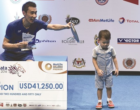 Malaysiau2019s Lee Chong Wei calls his son Kingston for a photograph on the podium after defeating Chinau2019s Chen Long in the menu2019s singles final to win the 2016 Malaysia Open Badminton Superseries at the Malawati stadium in Shah Alam yesterday. (AFP)