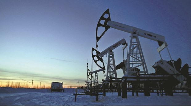 Pump jacks are seen at the Lukoil-owned Imilorskoye oil field as the sun sets outside the West Siberian city of Kogalym, Russia, in this January 25, 2016 file photo. Oil producers in Russia have raised output to post-Soviet highs as a weak rouble, cheap taxes and low costs spur drilling, while crude consumption by European refiners has jumped as a decline in feedstock expenses boosted profitability.