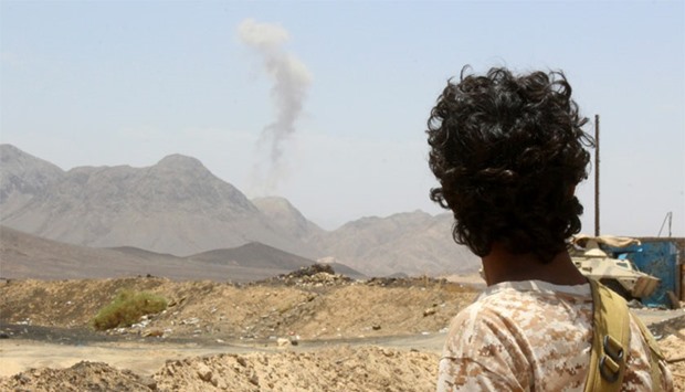A Yemeni fighter loyal to exiled President Abedrabbo Mansour Hadi looks at smoke rising in the distance in the Sirwah area, in Marib province today, during clashes with Shia Houthi rebels.  AFP