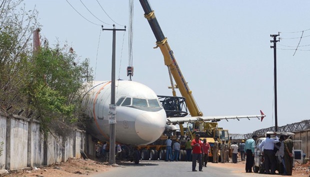 Police and rescue officials gather in front of a disused Air India passenger plane which fell from a ground transporter while being moved near Begumpet Airport in Hyderabad yesterday.