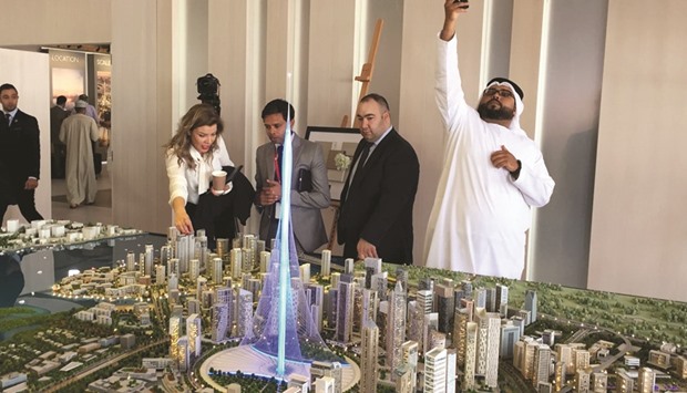 Visitors looking at a to-scale model of a new tower the real estate giant Emaar Properties plans to build that will break the record and be taller than the Burj Khalifa, currently the worldu2019s tallest tower, during an exposition in Dubai yesterday.