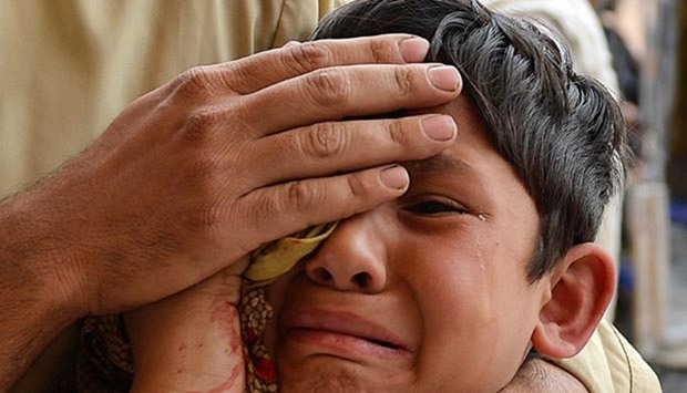 An injured Pakistani boy reacts as he arrives at a hospital following an earthquake in Peshawar.
