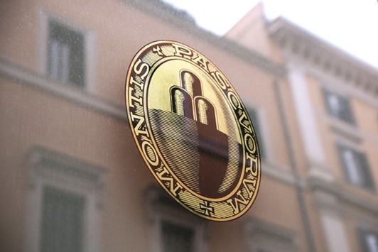 The Banca Monte dei Paschi di Siena logo sits on a window at one of the companyu2019s bank branches in Rome. Shares in the bank jumped 9.8% yesterday.