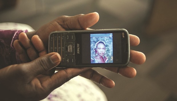 Yana Galang, the mother of Rifkatu Galang, one of the abducted Chibok girls, holds a phone with a picture of her daughter.