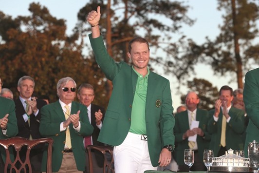 Danny Willett of England celebrates with the green jacket.