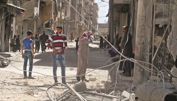 Residents inspect damages after an airstrike on the rebel held al-Maysar neighbourhood in Aleppo, Syria, yesterday.