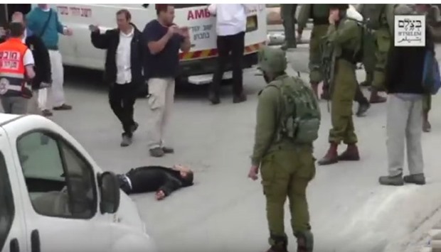 An image grab from a video that shows the shot Palestinian Abdul Fatah al-Sharif lying on the road surrounded by Israeli soldiers