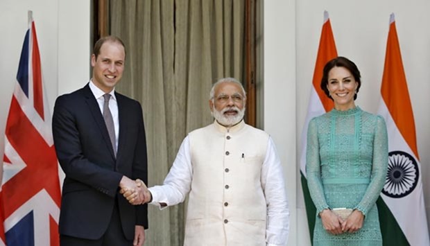 Prince William shakes hands with Prime Minister Narendra Modi as Catherine, Duchess of Cambridge, smiles at Hyderabad House in New Delhi on Tuesday.