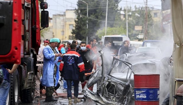Security and civil defence members inspect a car wreck after an explosion that killed Fathi Zaydan in Sidon on Tuesday.