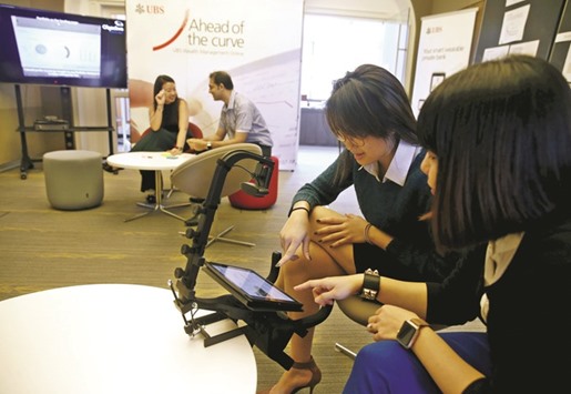 UBS employees demonstrate how their eye movements are being tracked to provide feedback on the interface design of a banking application on a tablet computer at their innovation centre in Singapore.