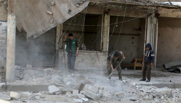 Residents remove debris after an airstrike in Aleppo