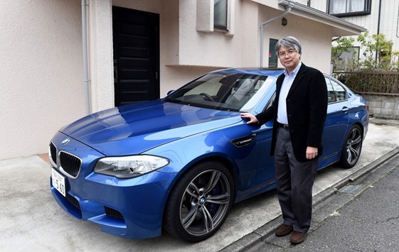 Randal Furudera poses beside his BMW M5 at his home in Tokyo. Deep-pocketed buyers like Furudera are driving sales in Japan of high-end foreign brands, which dominate the niche sector in a car market long seen as all but shuttered to overseas automakers.
