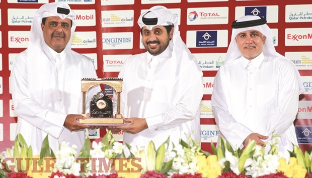 Qatar Racing and Equestrian Club (QREC) general manager Nasser Sherida al-Kaabi (centre) presents a memento to Brigadier Khalid bin Hamad al-Attiyah (left) at the QREC yesterday. PICTURES: Juhaim