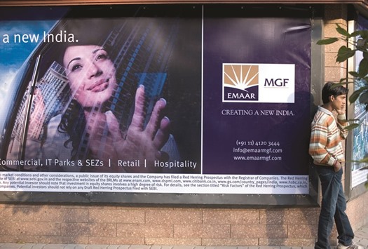 A young man is seen speaking on the phone next to a banner of Emaar MGF in New Delhi in this file photo dated January 31, 2008. The Dubai-based developer, known for building the worldu2019s tallest building in the emirate, the Burj Khalifa, entered the Indian market in 2005 through its partnership with MGF.