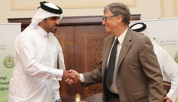 Bill Gates (R), Microsoft founder and co-chairman of the Bill and Melinda Gates Foundation, shakes hands with Khalifa bin Jassim al-Kuwari, the Director General of the Qatar Development Fund, during the signing ceremony in Doha. AFP