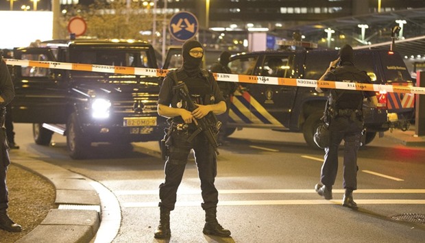 Dutch police stand guard by a cordoned off area outside Amsterdamu2019s Schiphol Airport late on Tuesday, after it was partially evacuated following a security alert.