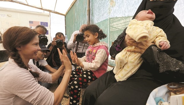 American actress Ashley Judd, UN Population Fund (UNFPA) Goodwill Ambassador, playing with Syrian children during her visit to Al Zaatari refugee camp in the Jordanian city of Mafraq, near the border with Syria, this week.