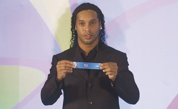Brazilian footballer Ronaldinho holds a slip showing u2018Brazilu2019 during the draw ceremony held in Rio de Janeiro. (Reuters)