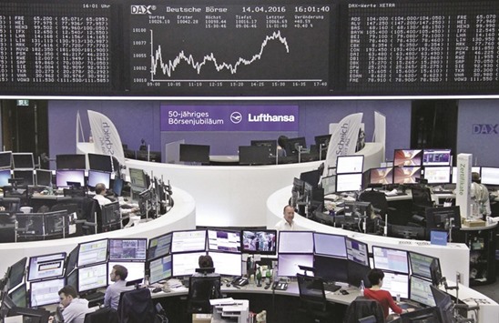 Traders work at their desks in front of the DAX board, at the Frankfurt Stock Exchange. The DAX 30 index added 0.7% yesterday in its fifth consecutive session of gains.