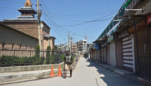 A paramilitary trooper patrols during a curfew near the Jamia Masjid mosque in Srinagar yesterday.