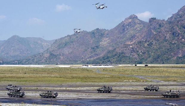 Two V-22 Osprey aircraft hover above Philippine and US marines during a live fire exercise as part of Balikatan joint US-Philippine military drills at Crow Valley.
