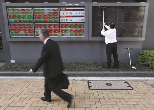 A man cleans electronic boards showing Japanu2019s Nikkei average, the exchange rate between the yen against the US dollar and stock quotation outside a brokerage in Tokyo yesterday. Bank of Japan policymakers are wary of intervening too heavily in the stock market, but its primary monetary easing tools u2013 cutting interest rates and buying government bonds u2013 are showing diminishing returns and have become less attractive since it adopted negative interest rates in January, sources said.