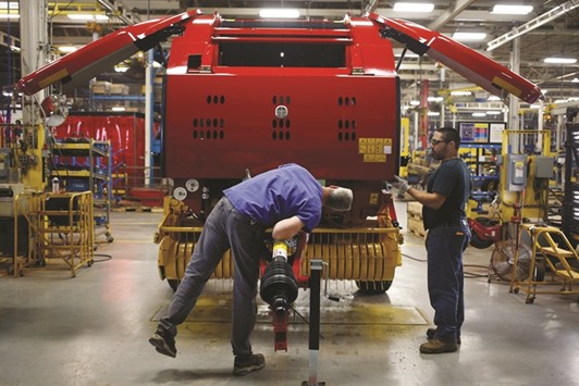 Workers review an assembled New Holland round baler at the companyu2019s Haytools factory in Pennsylvania, the US. Manufacturers are still under pressure from tepid overseas markets while last yearu2019s surge in the dollar and plunge in commodities prices continue to make an impact.