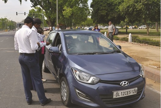 Indian traffic police check with the driver of a car with an even-numbered license plate as the latest round of odd-even car restrictions got underway in New Delhi yesterday.