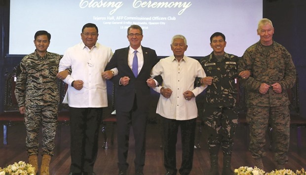 US Defence Secretary Ash Carter (third left) and other Philippine government and military officials link arms during the closing ceremony of a US-Philippine military exercise dubbed u201cBalikatanu201d (shoulder to shoulder) at Camp Aguinaldo in Quezon City, Metro Manila yesterday. (From left) Philippinesu2019 Vice Admiral Alexander Lopez, Foreign Affairs Secretary Rene Almendras, Carter, Defence Secretary Voltaire Gazmin, Armed Forces Chief Hernando Iriberri and Lieutenant-General John Toolan, commander of US Marine forces in the Pacific.