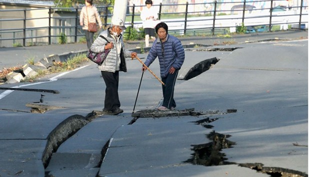 Local residents look at cracks caused by an earthquake on a road in Mashiki town, Kumamoto prefecture, southern Japan. AFP