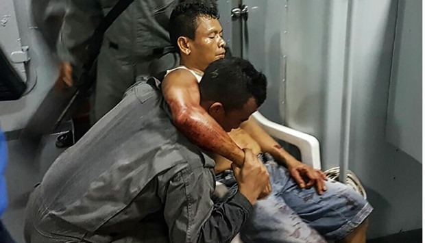 A member of Malaysian Maritime Enforcement Force rescuing an Indonesian sailor after being shot during a kidnapping at the east coast of Malaysia's Sabah state in Lahad Datu.