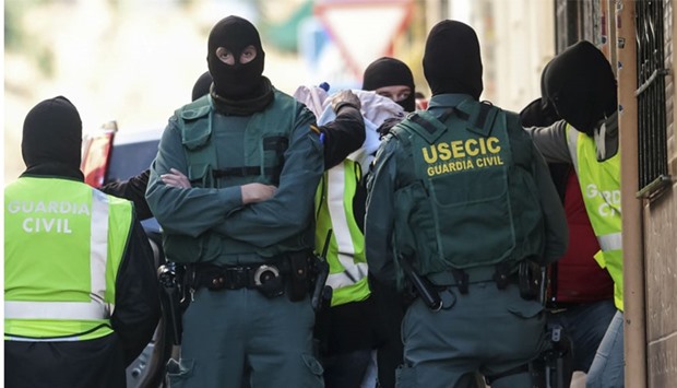 Spanish civil guard members lead a person arrested on suspicion of links to militant group Islamic State after a house search in Granada, southern Spain. Reuters