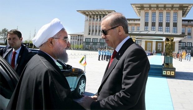 Turkish President Tayyip Erdogan (R) shakes hands with his Iranian counterpart Hassan Rouhani