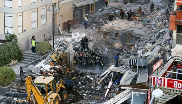 Firefighters and rescue workers search for survivors after a building collapsed in Los Cristianos