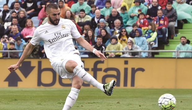 Real Madrid's French forward Karim Benzema scores the opening goal in his club's 5-1 thrashing of Getafe in their Spanish league match yesterday. (AFP)