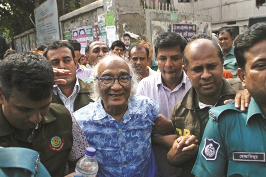 Security personnel escort Shafik Rehman, centre, at a court following his arrest in Dhaka yesterday.