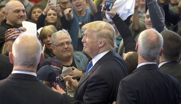 Republican US presidential candidate Donald Trump  autographing a cap during a rally in Plattsburgh, New York.