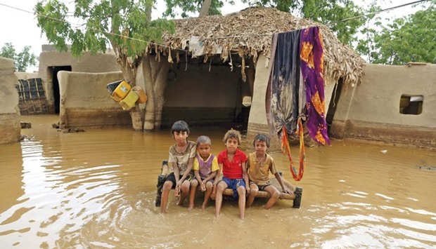 Children sit on a bed in a flooded house following heavy rain in a village in Yemenu2019s Red Sea province of Houdieda on Friday.