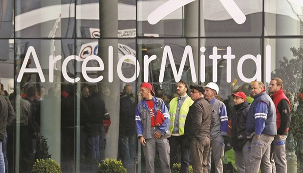 ArcelorMittal steel workers wait outside the companyu2019s regional headquarters in Flemalle, Belgium. The steelmaker, which produced a combined 92.5mn tonnes of steel from mills in the Americas, Europe, Africa and Asia last year, has posted a net loss for four straight years, including a $7.9bn in 2015.