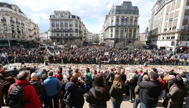 People stand by the makeshift memorial in the stock exchange square in Brussels during the peaceful march ,#Tousensemble - #Sameneen, against terrorism